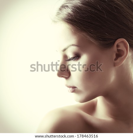 Beauty portrait of young woman with beautiful healthy face in profile, studio shot of attractive girl. Image toned.