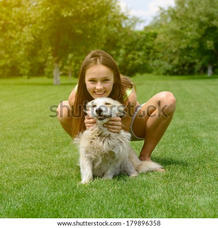 beautiful young happy laugh girl playing with her dog outdoor, toned