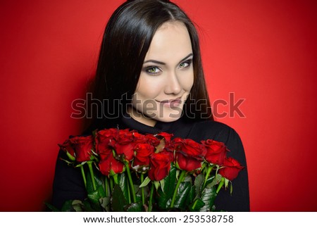 Beautiful Woman with Fresh Red Roses. Girl and Flowers over Red Background. Beauty Female Face. Happiness, Freshness, Beauty, Youth.
