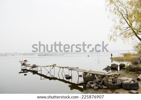 Atmospheric misty landscape with the river and the bridge across the Dnieper. Homemade bridges for fishing. Calm, meditation and balance