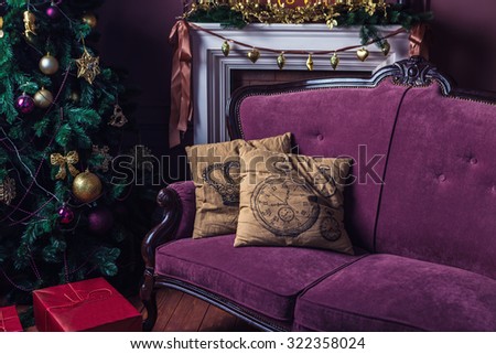 elegant interior Christmas decorations. Purple Sofa with two beige pillows stands next to a Christmas tree. Merry Christmas and happy New Year! A series of photos