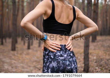 Sports injury Lower back pain woman holding body touching painful waist muscles showing smartwatch on wrist. Foto stock © 