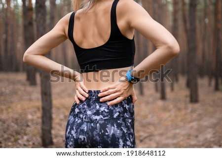Sports injury Lower back pain woman holding body touching painful waist muscles showing smartwatch on wrist. Foto stock © 