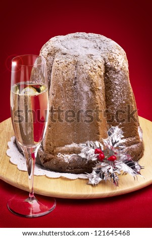 typical christmas cake with sparkling wine on red background