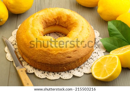 cake and yellow lemons on wooden board