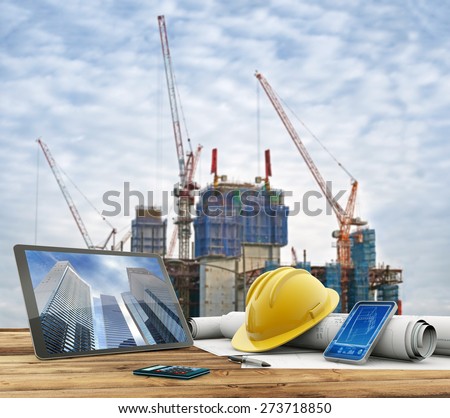 blueprints and safety helmet over a table in construction site