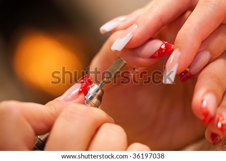 Macro closeup of nail polisher at work on french nails