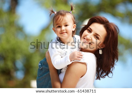 Young mother with child outside on a summer day