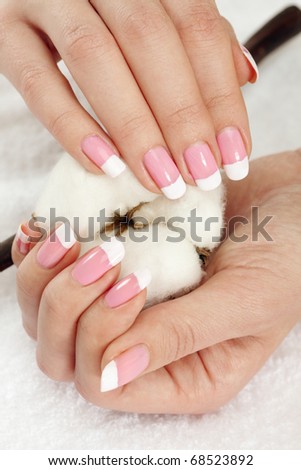Nicely manicured hands with cotton crop over a towel