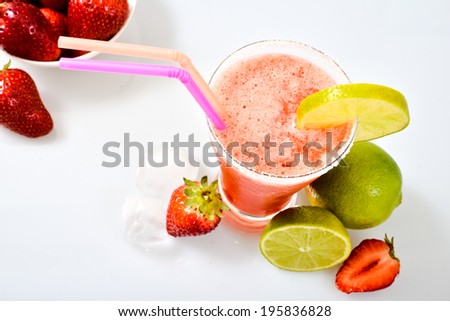 Frozen strawberry margarita isolated on a white background garnished with a salt rim and a lime wheel.