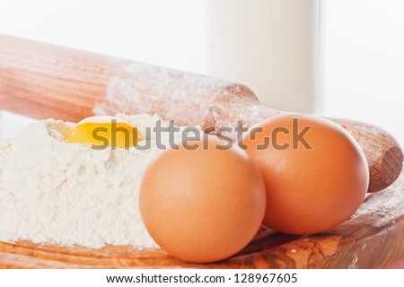 Vintage rolling pin with flour and eggs.