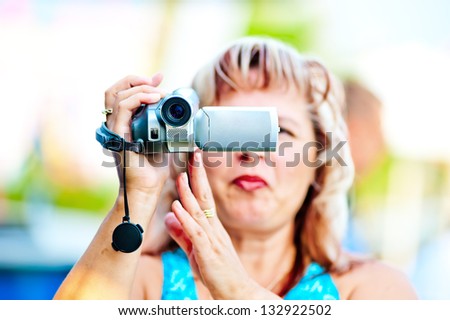 Woman shoots video with interest to the mini camcorder