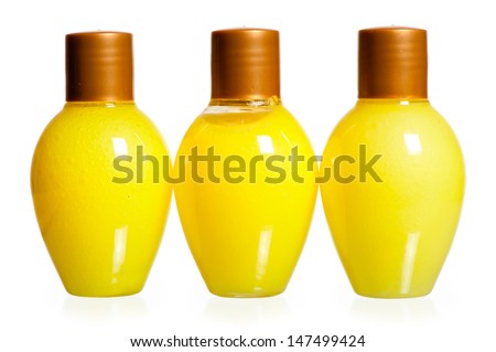 three yellow bottles of cosmetics on white background standing in a row