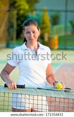 girl with a ball and a tennis racket at the net worth