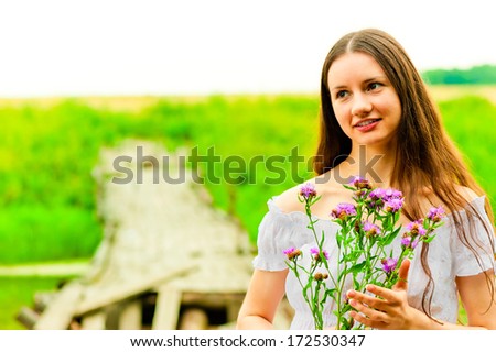 portrait of a beautiful girl with a bouquet on a background of field
