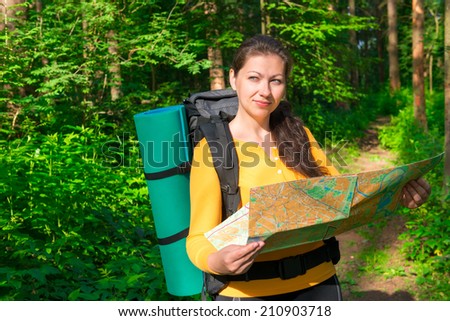 pensive tourist with map in a summer forest