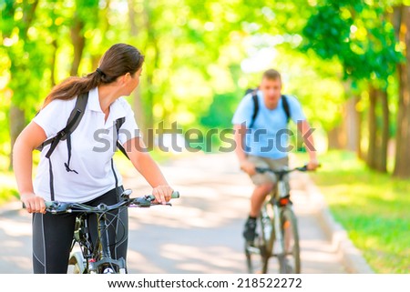 man and woman in the park on bicycles in the morning