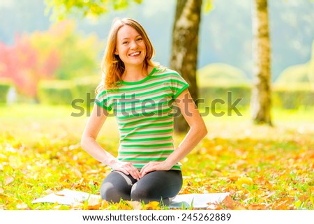 Yoga in autumn park. girl among the trees doing yoga
