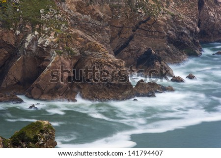 ocean wave washes over the rocky shore (Portugal, Atlantic Ocean, Cape Roca)