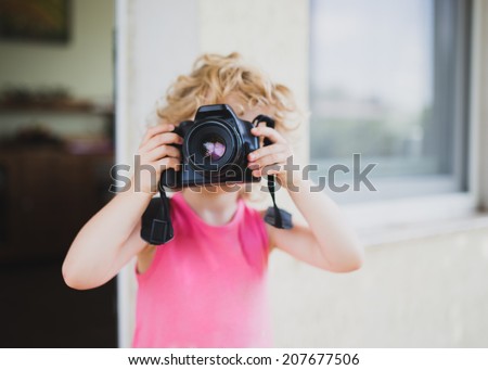 Little girl taking picture with SLR camera