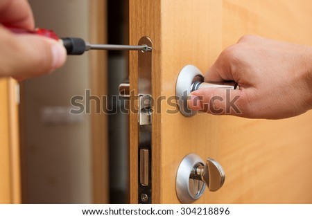 Man fixing the door handle with screwdriver