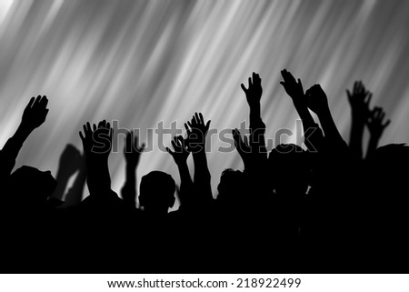 people rise hands in silhouette