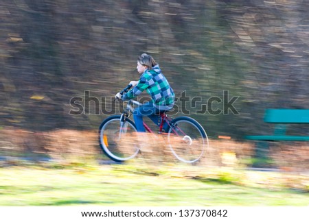Mountain biking in a park - Young biker on a park biking trail going fast (motion blurred image)