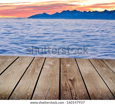 Landscape winter hill scene with fog and empty wooden deck table