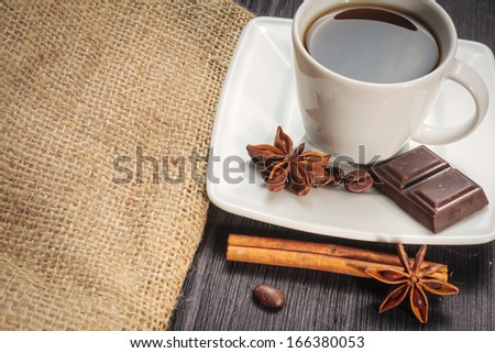 Cup of coffee with brown sugar on a wooden table.