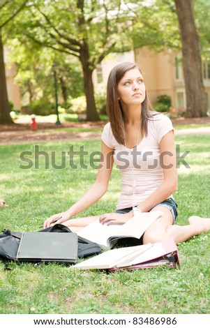pretty young college or high school student with laptop and books