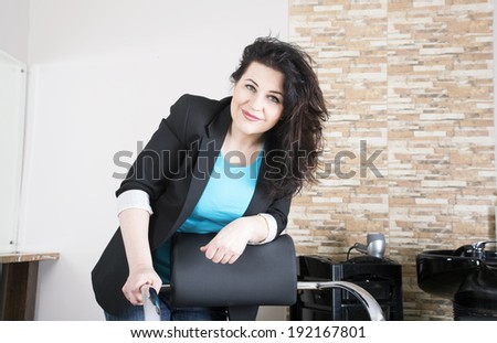 Hairdresser in workplace stands near a chair