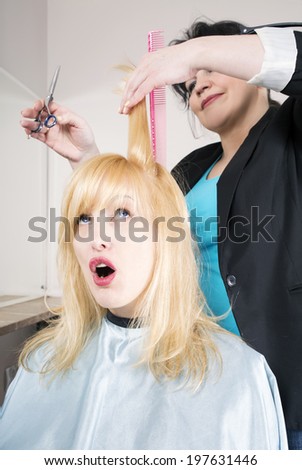 Hairdresser cuts (trims) blond long hair