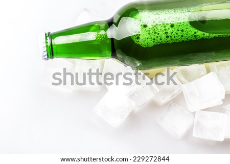 beer bottle in ice cubes isolated on white background