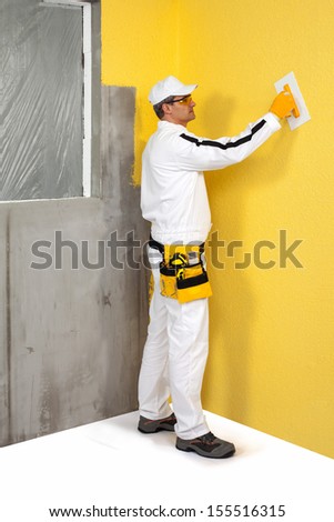 Worker spreading a plaster on a wall
