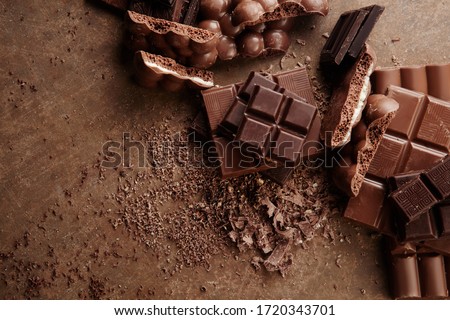 Composition of bars and pieces of different milk and dark chocolate, grated cocoa on a brown background top view close up Imagine de stoc © 