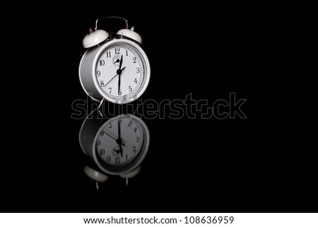 Alarm clock with dark background and reflection.