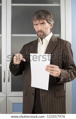 angry man in business suit shows blank sheet of paper