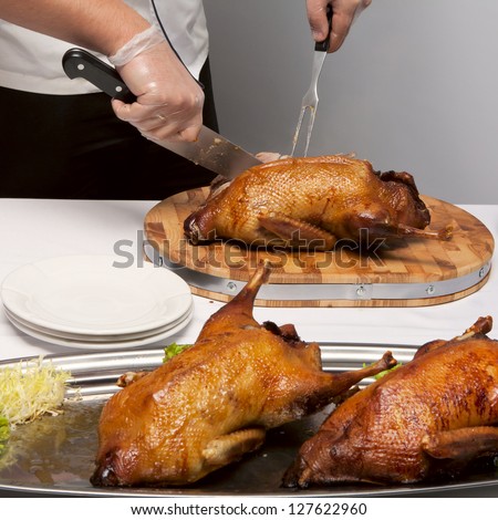 cook cut up roast duck on wooden carving board
