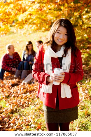 Asian woman drinking a warm drink in the fall