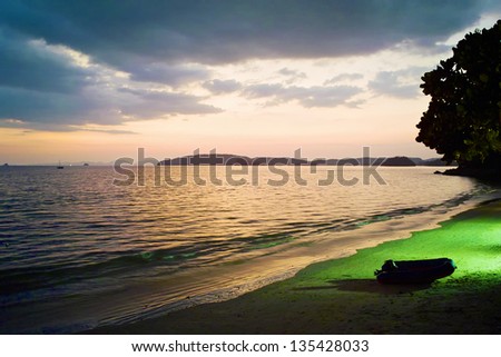 Tropical beach with an inflatable boat ashore in Thailand at night