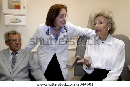 Caring female geriatrician with her elderly patients discussing senior health issues