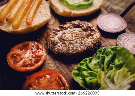 Homemade burger ingredients arranged on vintage wooden plate