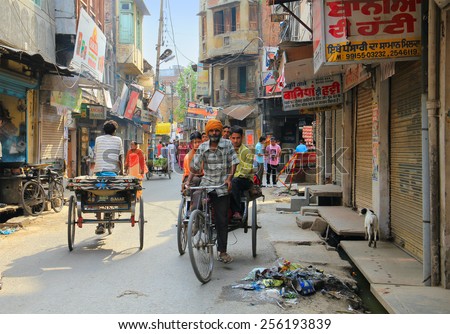 AMRITSAR/INDIA - JUNE 17. Indian city street full of people and cycle rickshaws on June 17, 2014 in Amritsar, Punjab, India. Cycle rickshaw is steel popular kind of transport in Indian towns.