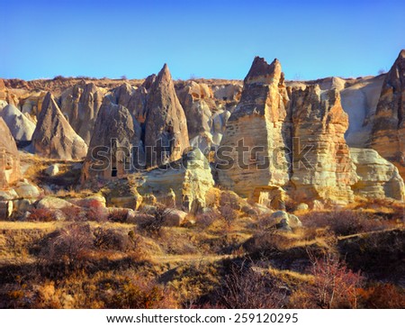 Beautiful barren landscape - ashen mountains (volcanic rocks) - eerie carved and hollowed out structures at the evening in Rose Valley, Goreme, Cappadocia, Central Anatolia, Turkey