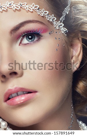 close up of young woman in creative and artistic white make-up, perfect hairstyle