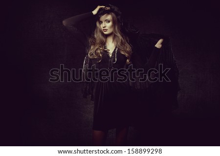 fashion photo of gothic girl in Halloween dress against the wall