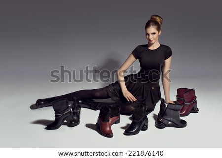 young beautiful woman in black dress posing with shoes