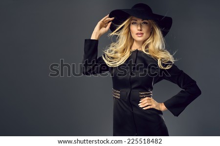 Pretty young lady wearing black hat, in a fashion pose