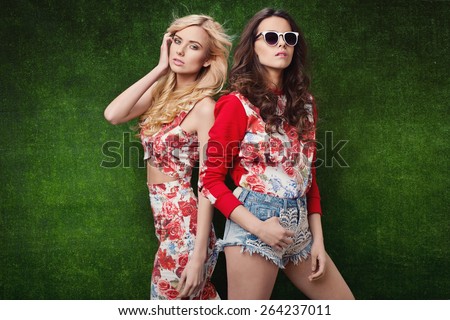 beautiful young women in nice spring clothes, posing in studio on grass. Fashion photo