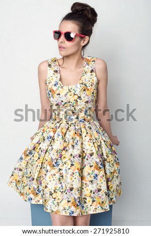 beautiful young woman in nice spring dress, flower pattern posing in studio. Fashion photo